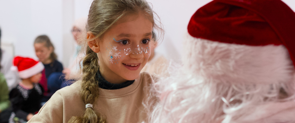 Kind mit Fluchtbiografie freut sich über Geschenk vom Weihnachtsmann